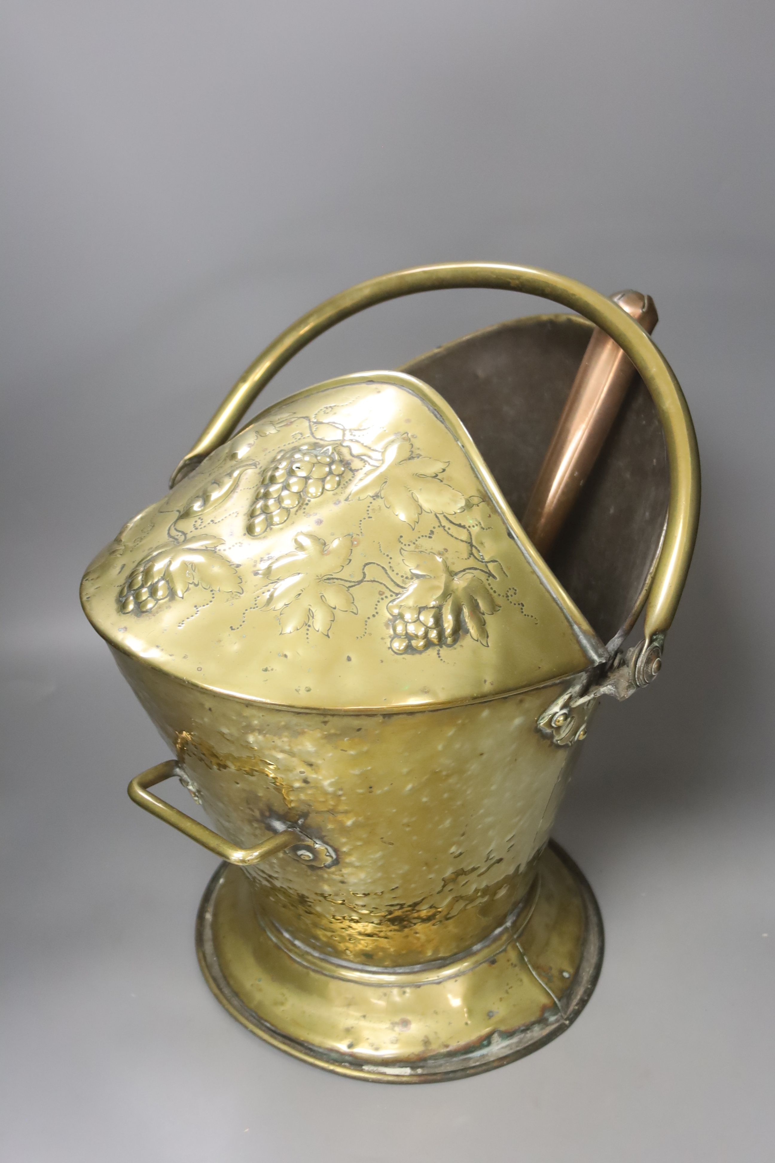 A brass coal bucket, a dolphin door porter, a scoop and a small pail, tallest 47cm